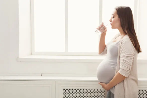 Mulher grávida tomando um copo de água